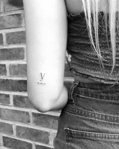 a woman with a small v tattoo on her arm