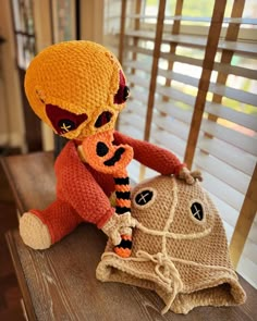 a stuffed animal sitting on top of a wooden table next to a bag and window