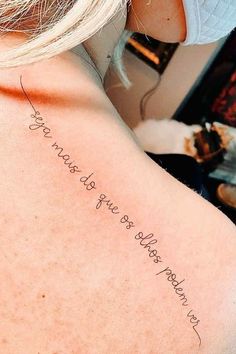 the back of a woman's shoulder with an inscription written in cursive writing