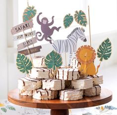 there is a cake on the table with animals and zebras around it that says safari