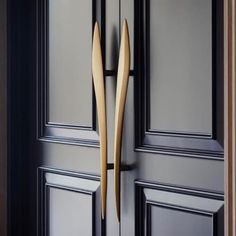 the door handle is made out of wood and has two long curved wooden sticks sticking out of it