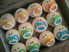 twelve cupcakes in the shape of pacifier faces