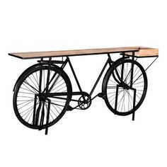 an old fashioned bicycle is mounted on a wooden table with metal bars and spokes