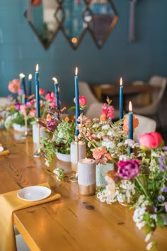 a long table with flowers and candles on it