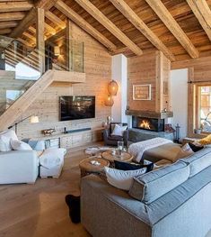 a living room filled with furniture and a fire place in the middle of a room