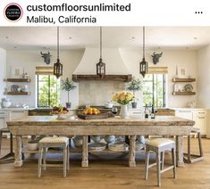 a large wooden table sitting in the middle of a kitchen