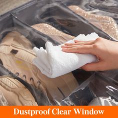 someone is cleaning their shoes in the dust proof clear window bag with a cloth on it