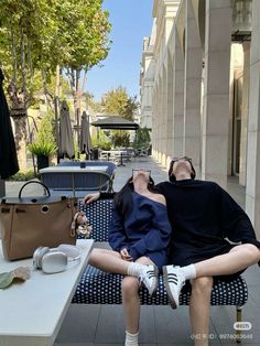 a man and woman laying on a bench next to each other