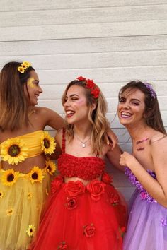 three young women dressed in colorful dresses standing next to each other