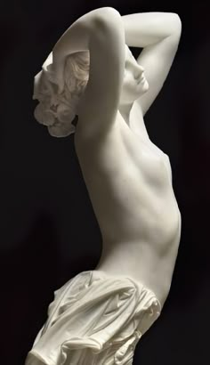 a white statue is shown against a black background and has its back turned to the camera