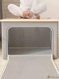 a woman sitting on top of a desk with her legs crossed in front of the table