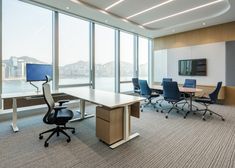 an empty conference room with chairs and desks in front of large windows looking out onto the water