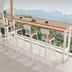 there are four stools at the bar on the balcony overlooking the cityscape