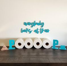 three rolls of toilet paper sitting next to each other on top of a wooden table