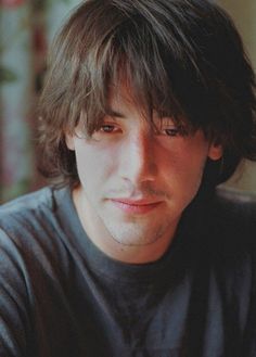 a close up of a person wearing a black t - shirt and looking at the camera