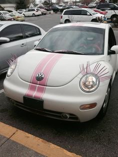 a white car with pink stripes parked in a parking lot