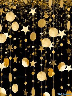 gold stars and moon mobiles hanging from strings against a black background with golden confetti