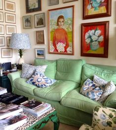 a living room filled with lots of furniture and pictures on the wall above it's coffee table