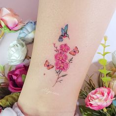 a woman's leg with flowers and a butterfly on it