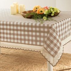 a table topped with a bowl of flowers next to two candles and a basket of flowers