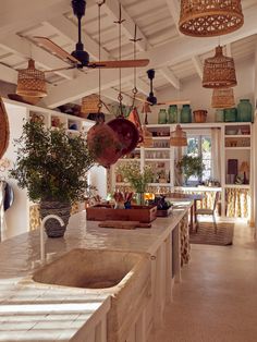 a kitchen filled with lots of counter top space and hanging baskets on the ceiling above it