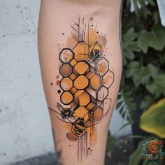 a tattoo on the leg of a woman with honeycombs and bees in it