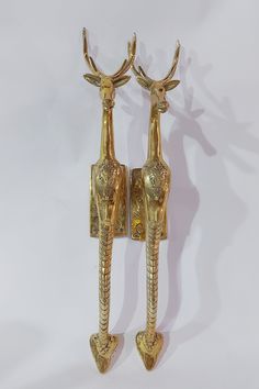 two golden wall sconces with deer heads on each one and an elephant head on the other