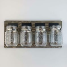 three mason jars are hanging on the wall