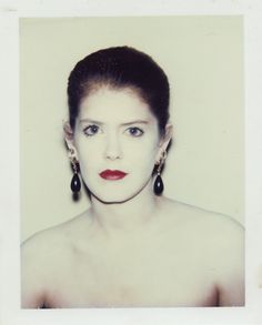 a woman with red lipstick and large earrings