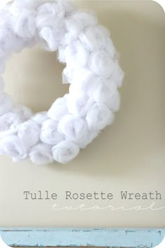 a white yarn wreath hanging on a wall