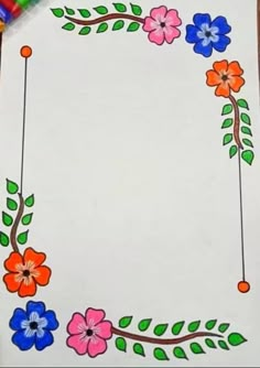 a paper with flowers on it and colored pencils in front of the drawing board