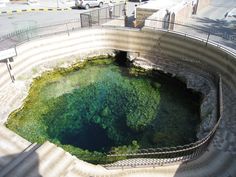 the water is very green and clear in this large hole with stairs leading up to it