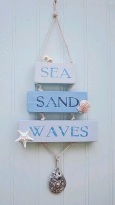 a wooden sign hanging on the side of a wall next to a seashell and starfish