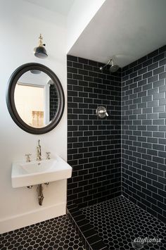 a bathroom with black and white tile on the walls