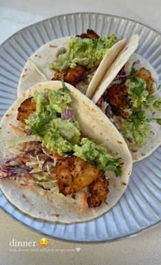 three tacos on a plate with lettuce and shrimp