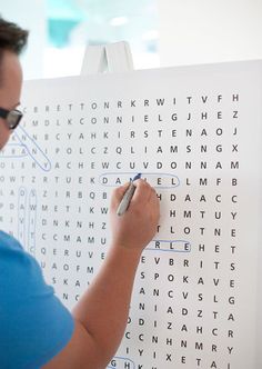 a woman is writing on a large white piece of paper that has words in it