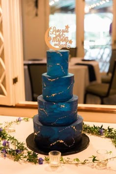 a blue wedding cake sitting on top of a table