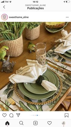 the table is set with green and white placemats, napkins, and plants