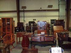 a room filled with lots of wooden furniture and chairs next to each other on display