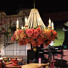 a chandelier with roses hanging from it's centerpiece in a restaurant