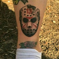 a tattoo on the leg of a person with a hockey mask on it's face