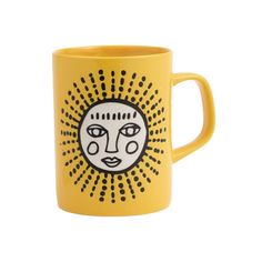 a yellow coffee mug with a face on it