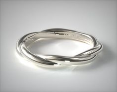 a silver ring on a white surface with light coming from it's center and bottom