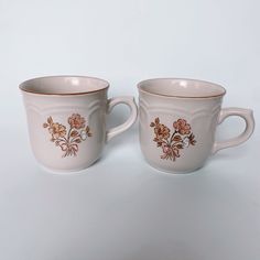 two coffee mugs sitting side by side on a white surface