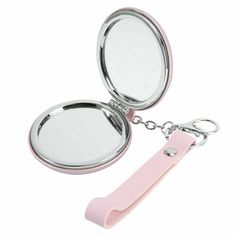 a compact mirror with a keychain attached to the front and back of it