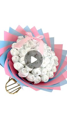 a pink and blue flower bouquet with a whisk in it's center