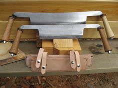 three knives are stacked on top of each other with wooden handles and leather sheaths