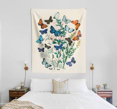 a white bed topped with a large tapestry covered in butterflies