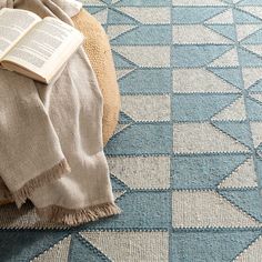 an open book sitting on top of a blue rug