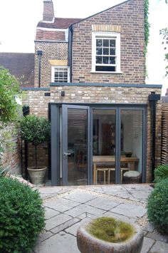 a brick building with an open patio and glass doors